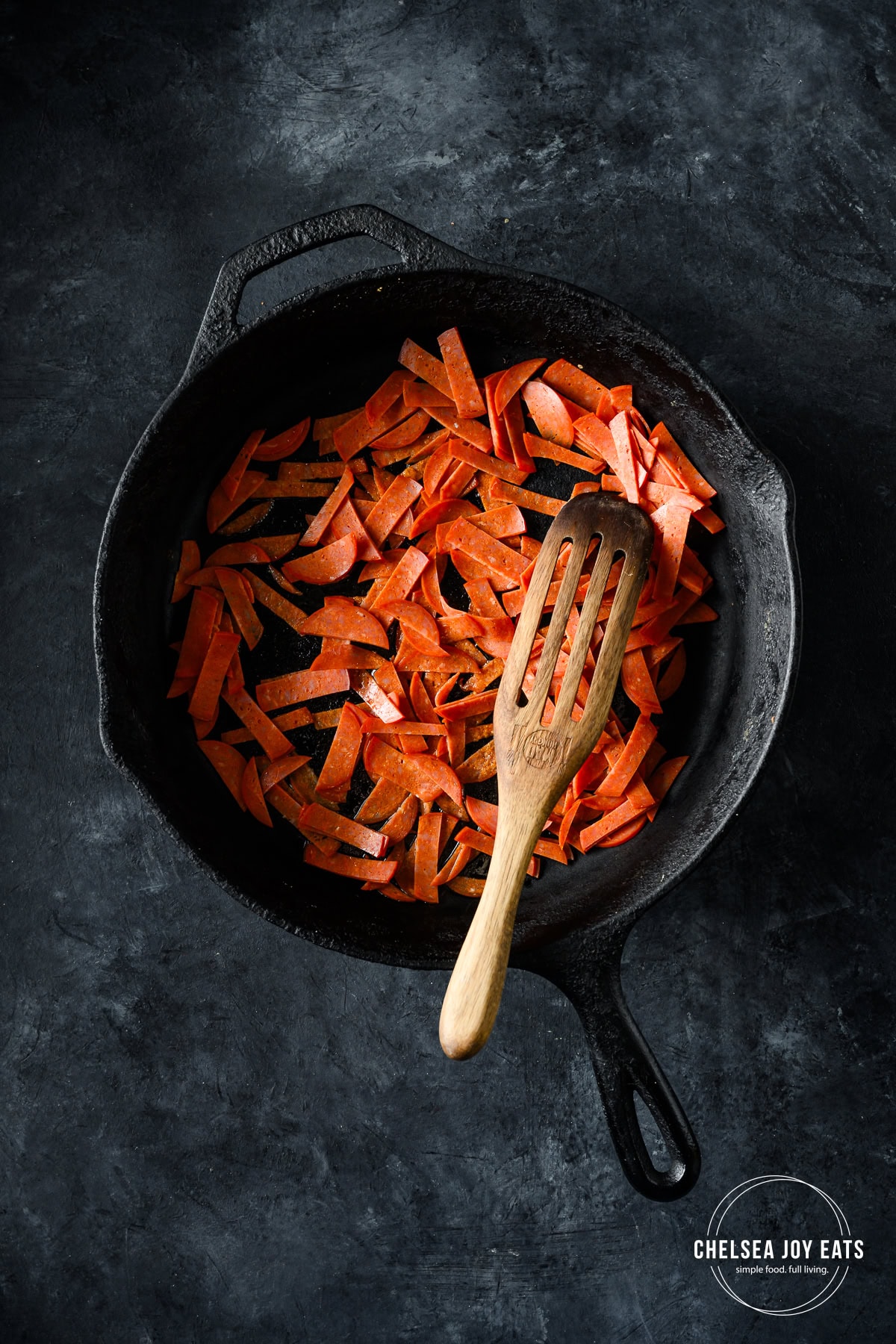 Overhead view of crisping pepperoni strips in a skillet