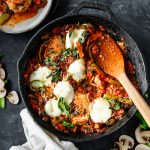 Overhead view of a chicken and pepperoni casserole served in a cast iron skillet