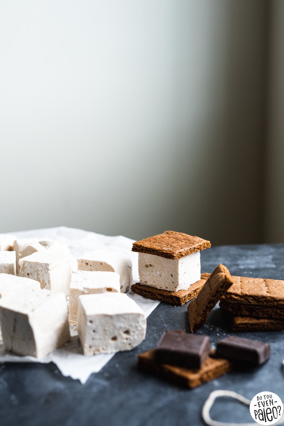 Homemade marshmallows and graham crackers being assembled into s'mores bars