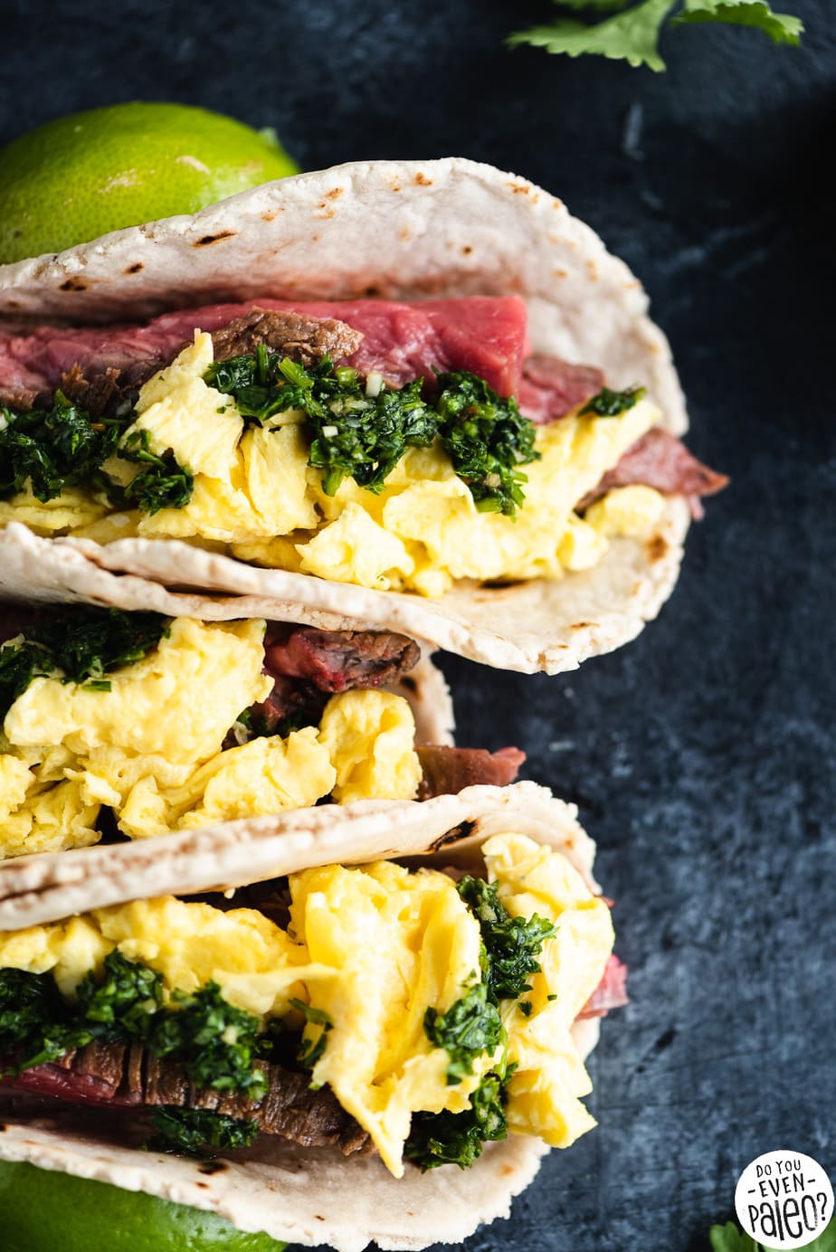 Closeup of Steak and Egg Breakfast Tacos with Chimichurri on a dark background