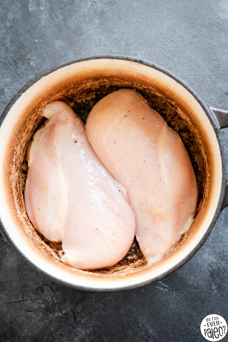 Raw chicken breasts sprinkled with salt in a dutch oven