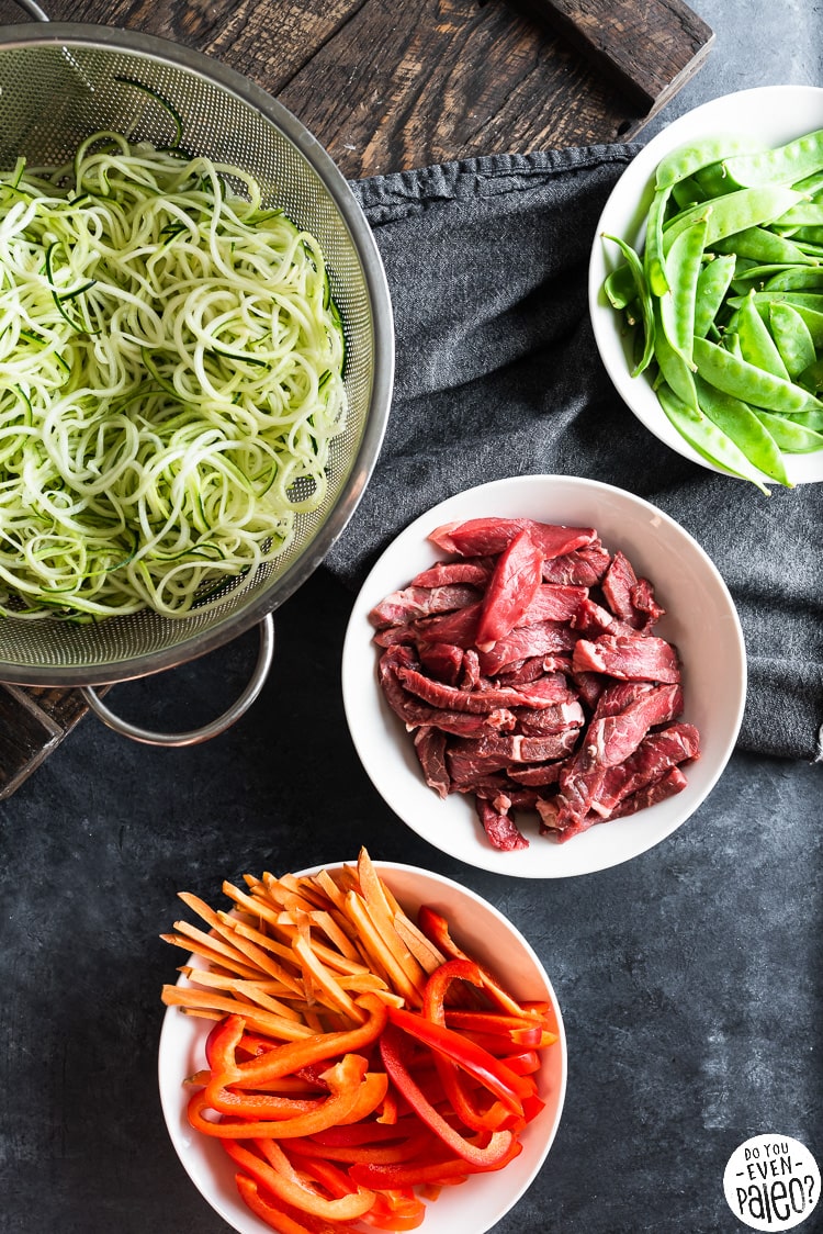 Bowls containing veggies and raw beef