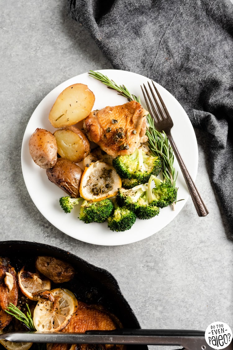 Plate with chicken thigh, broccoli, and roast potatoes in a lemon rosemary sauce