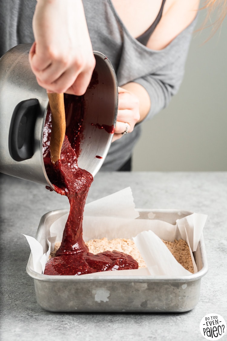 Person pouring a pot of stovetop jam over a crust in a baking pan