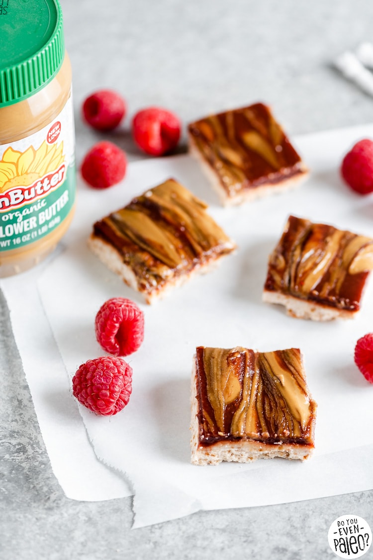 SunButter and Jelly Bars arranged next to raspberries and a jar of SunButter
