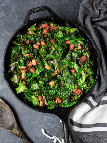 Cast iron skillet with sautéed collard greens and ham
