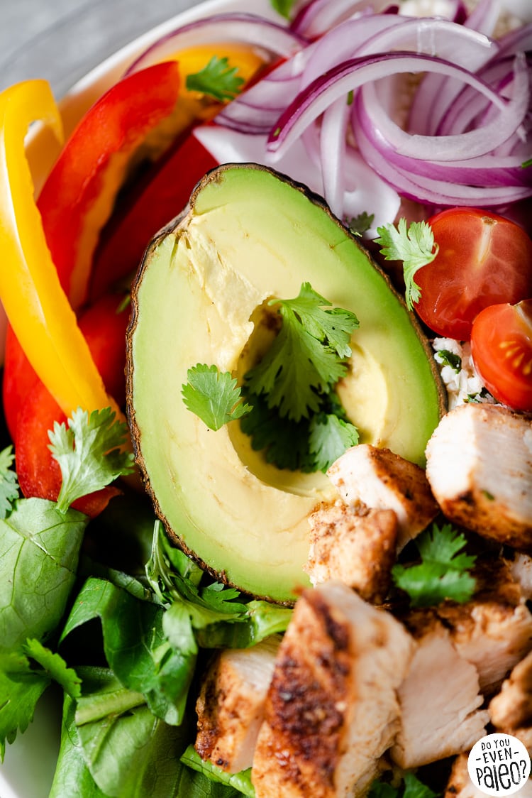 Closeup of an avocado on a bed of fresh veggies