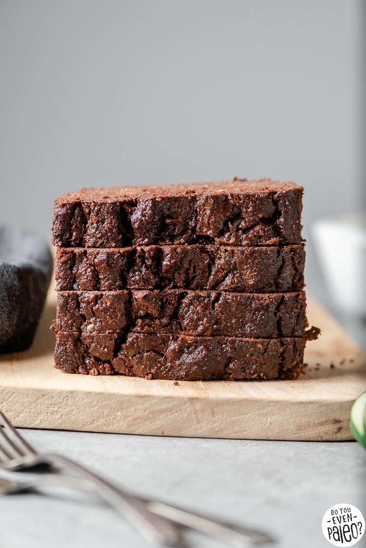 Slices of gluten free chocolate zucchini bread stacked on a cutting board