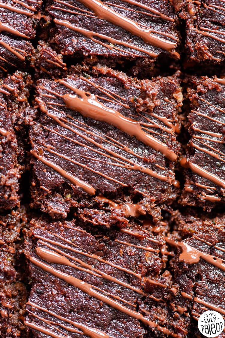 Closeup of paleo zucchini brownies, drizzled in chocolate