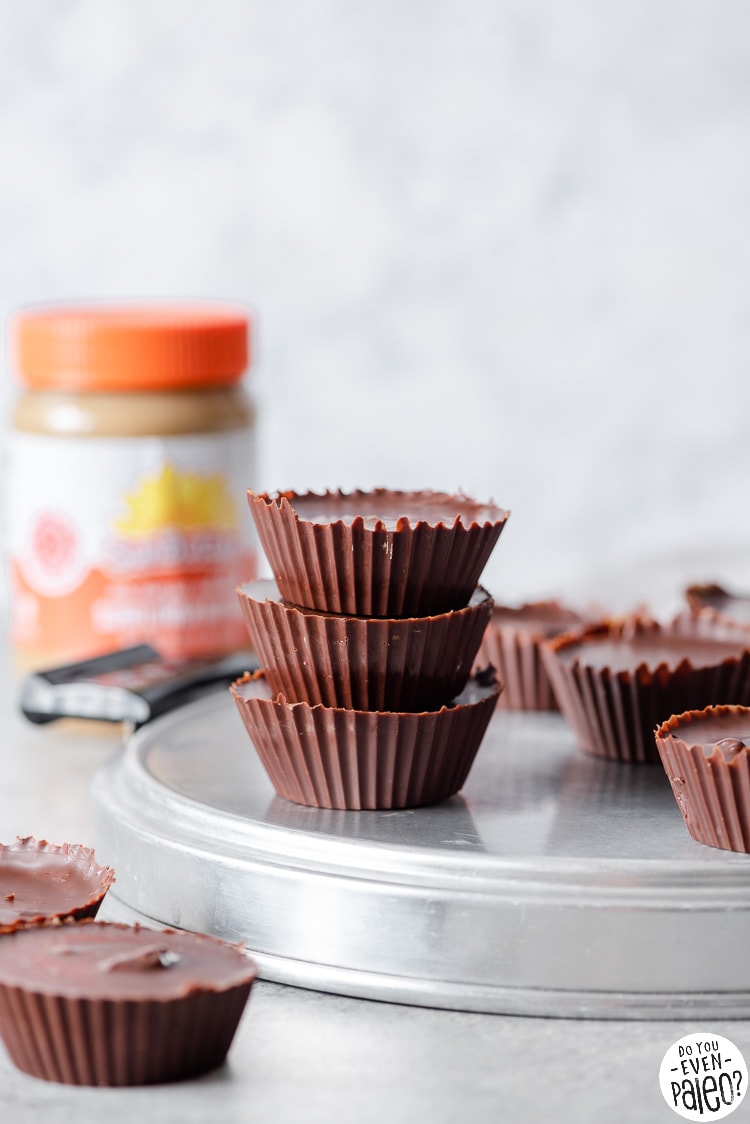 Stack of SunButter cups with a jar of SunButter in the background