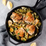 Cast iron skillet with roasted chicken thighs and broccoli