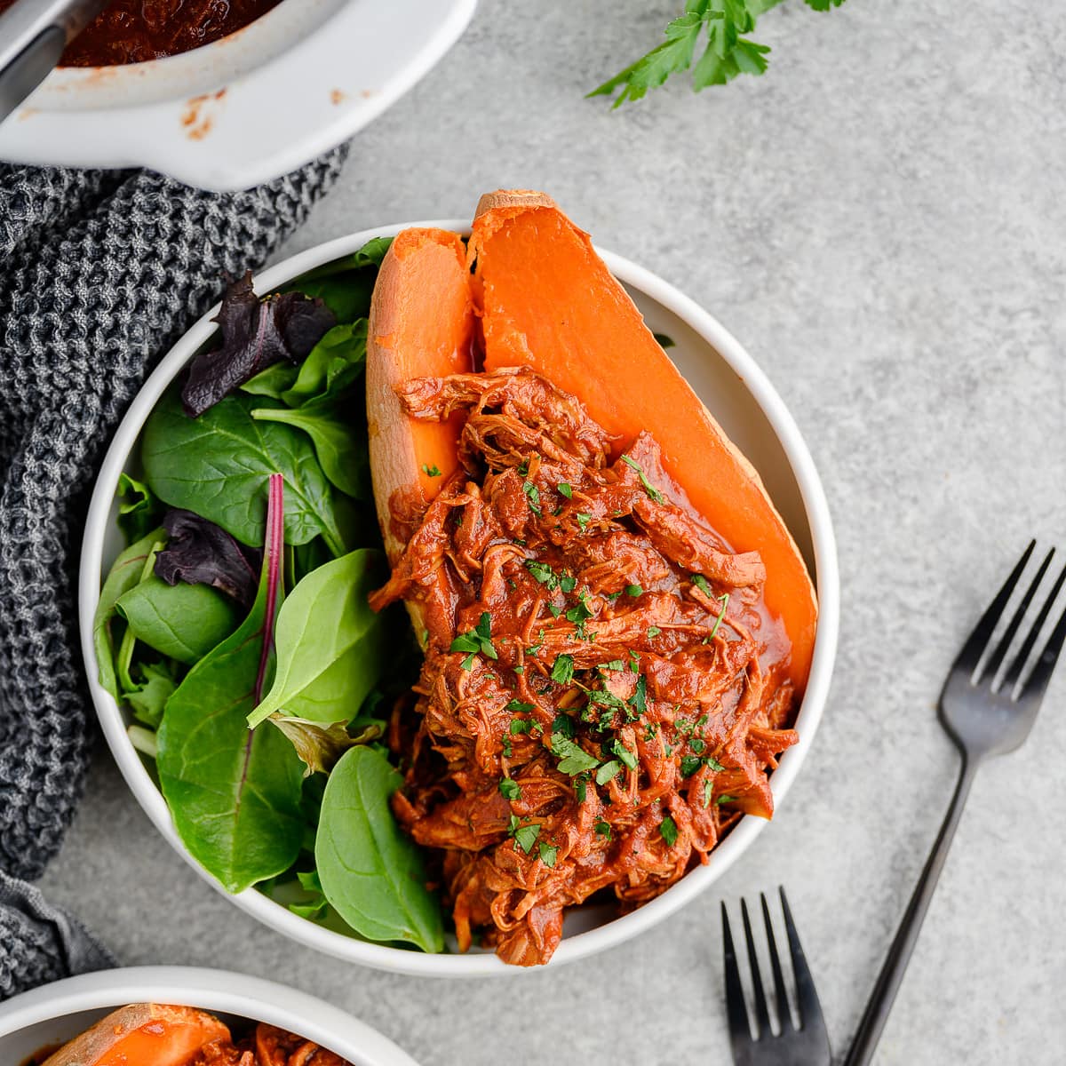 Bowl with salad greens and roast sweet potato topped with slow cooker BBQ shredded chicken