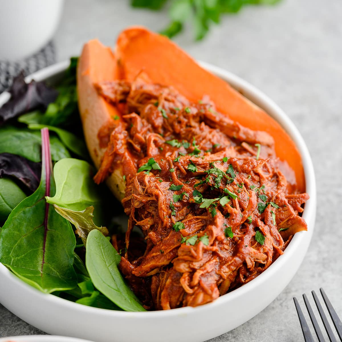 Easy BBQ shredded chicken served with a sweet potato and greens