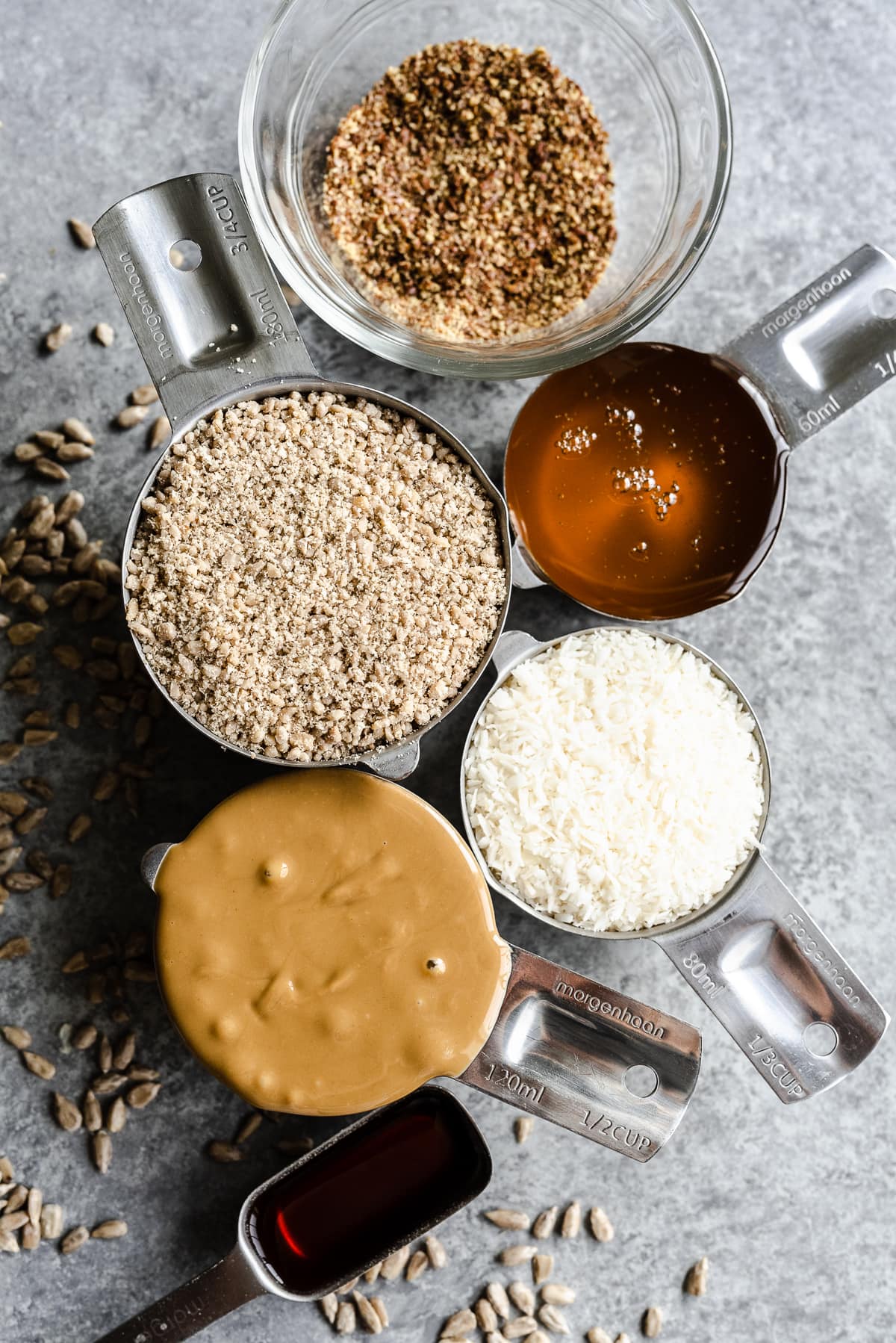 Ingredients for Nut free energy balls in measuring cups on a light background