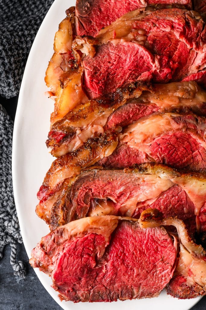 Closeup of slices of slow roasted prime rib on a serving platter