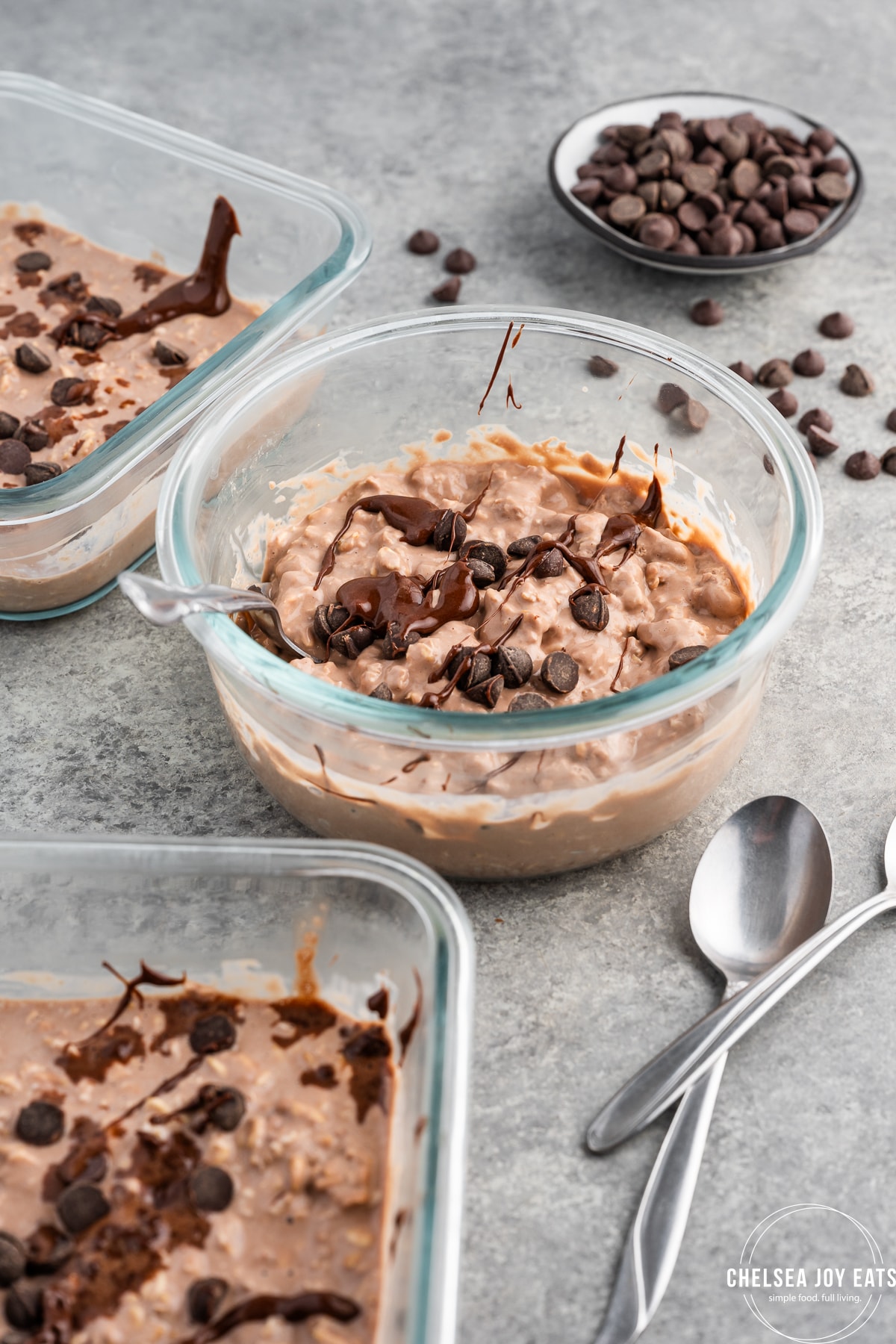 Bowls of chocolate protein overnight oats drizzled with chocolate