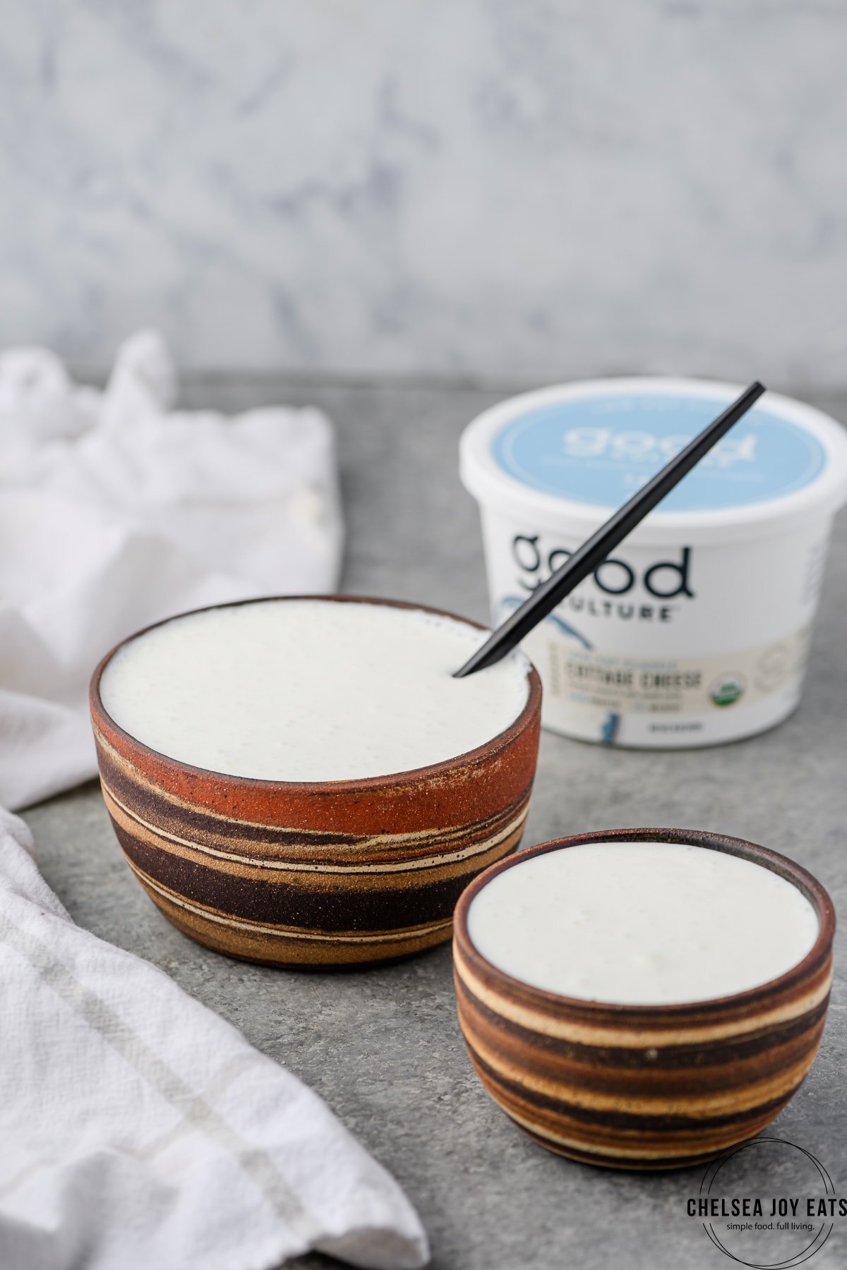 Bowls full of blended cottage cheese, with a cottage cheese container in the background.