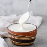 Bowl full of blended cottage cheese, with a spoon scooping some of the cottage cheese.