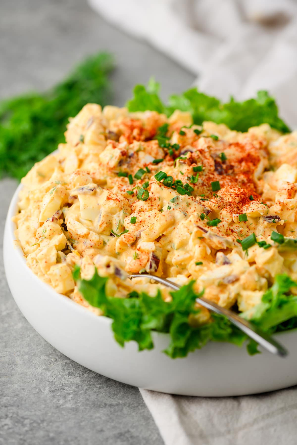 Closeup of egg salad served in a dish over lettuce