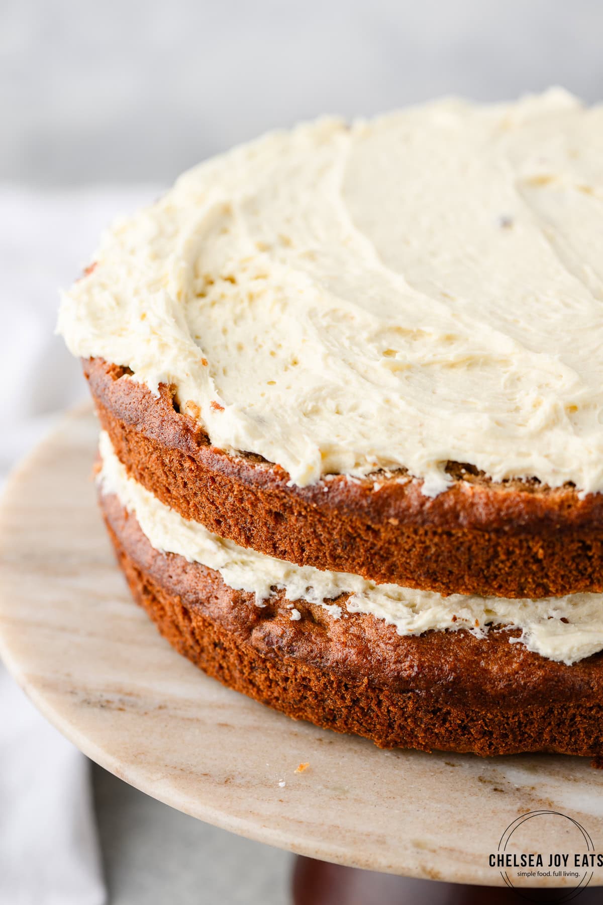 Closeup of two layers of gluten free hummingbird cake with cream cheese frosting in between layers