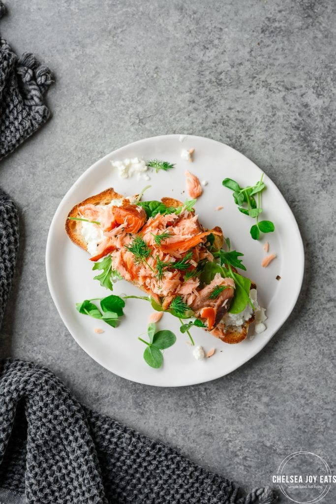Sourdough toast topped with cottage cheese, smoked salmon, greens, and dill