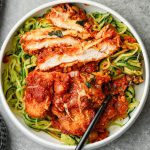 Sliced chicken parmesan cutlet served over zucchini noodles