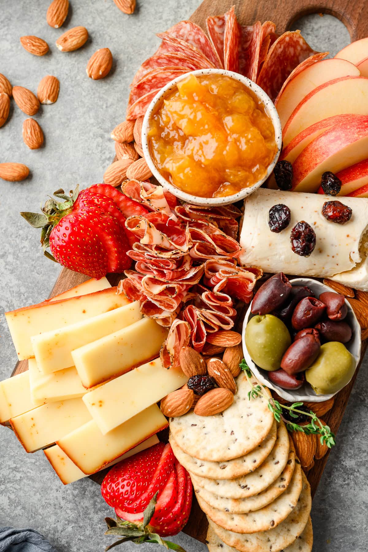 Small charcuterie board for two with different meats, cheeses, fruits, and nuts