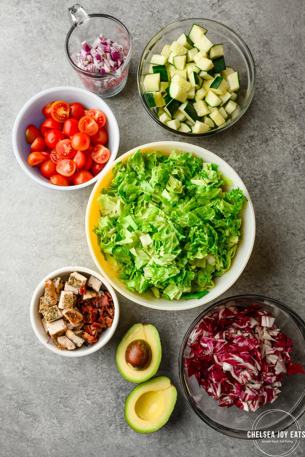 Overhead view of ingredients for a salad recipe in their own dishes