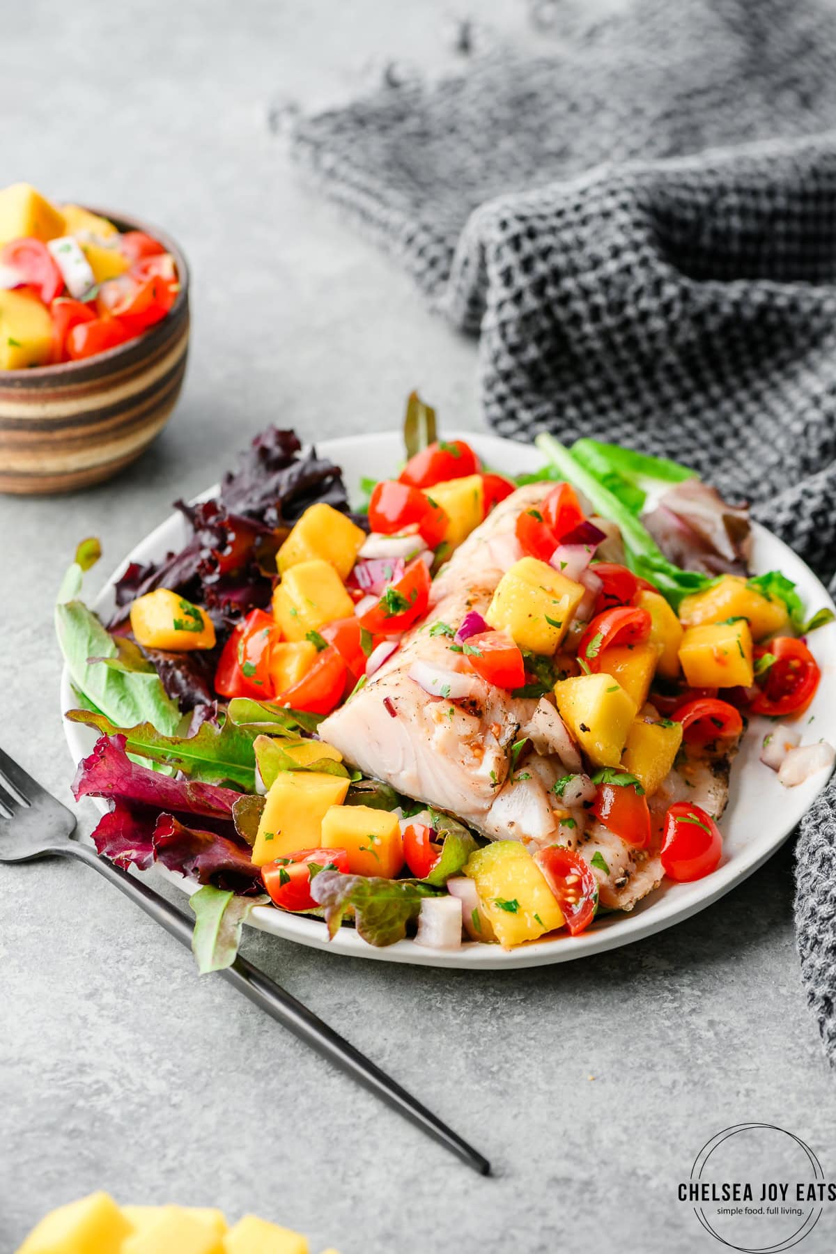 Fillet of grilled walleye over a bed of greens and topped with mango salsa