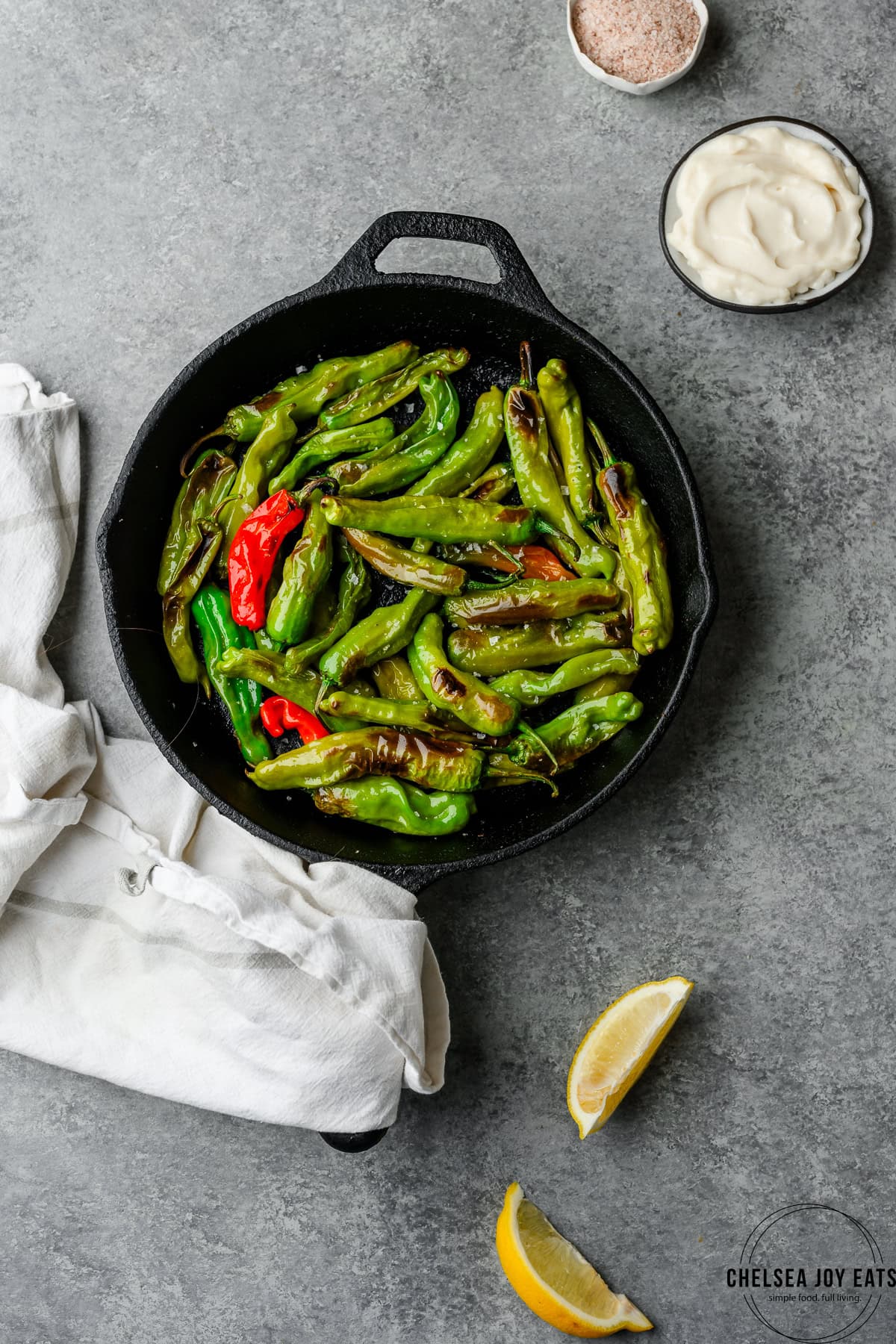 Cast iron skillet with blistered shishito peppers