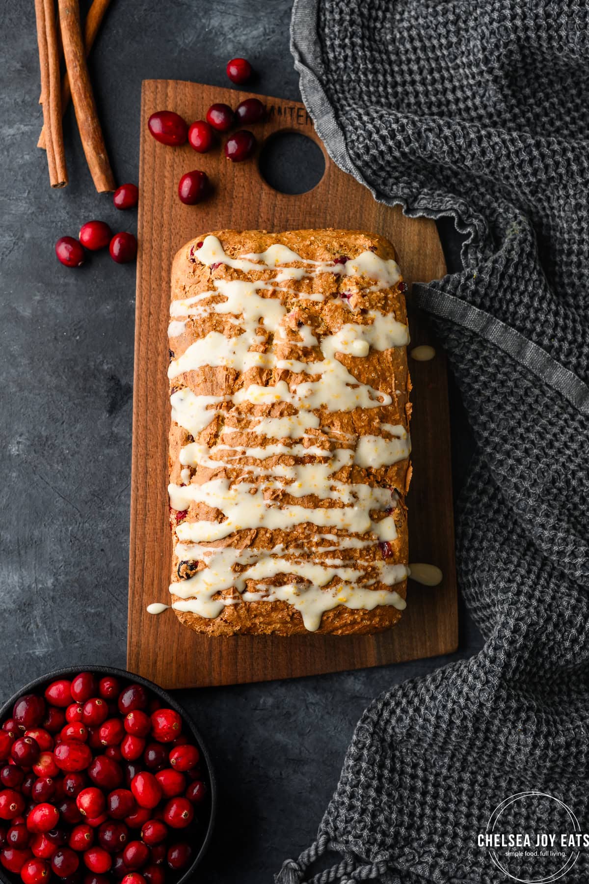 Overhead view of a loaf of cranberry quick bread, drizzled with orange icing