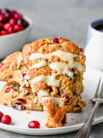 Gluten free cranberry orange scone propped up on more scones in the background