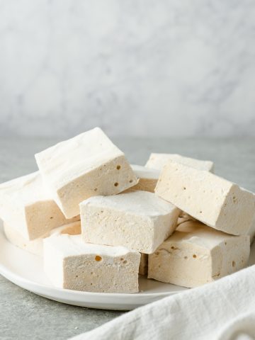 Plate piled with square-cut homemade marshmallows without corn syrup