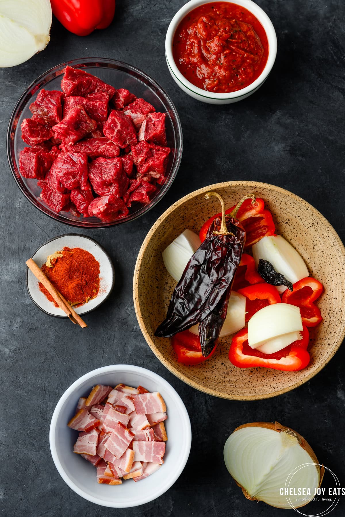 Ingredients needed for chuck roast chili without beans, including chuck roast, dried chiles, and bacon