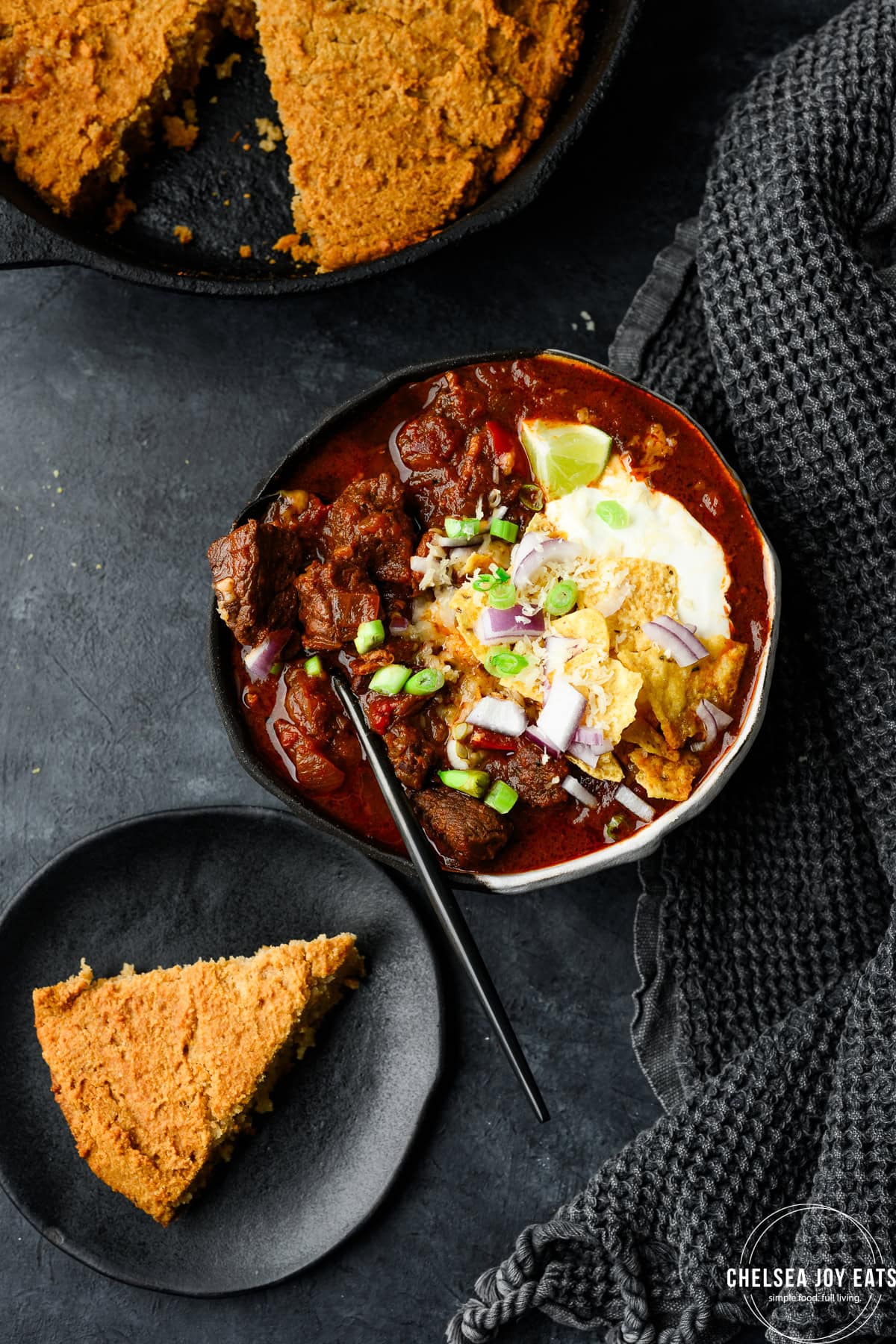 Bowl of chuck roast chili without beans alongside a plate of cornbread