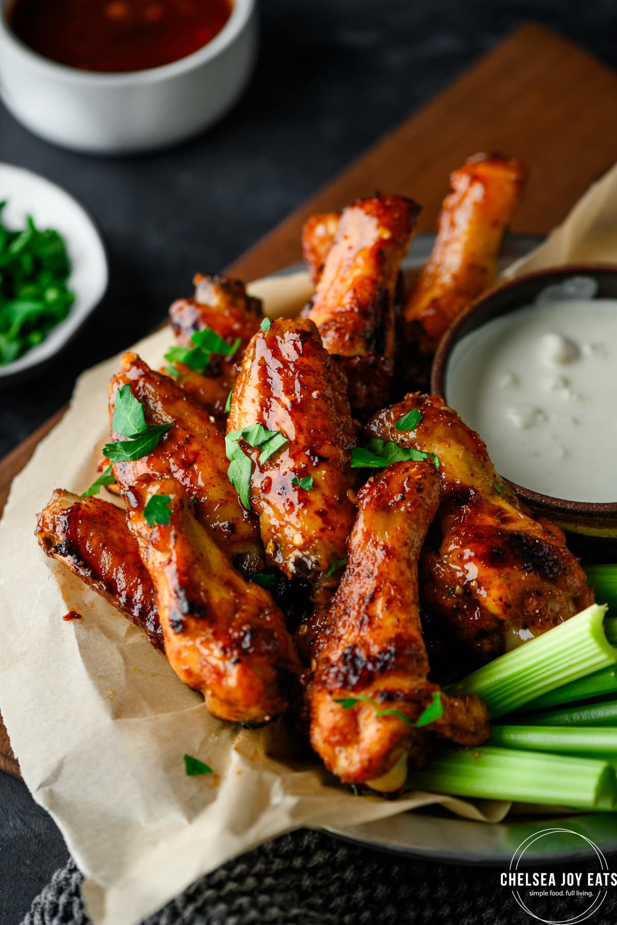 Closeup of hot honey chicken wings on a tray with celery and blue cheese sauce