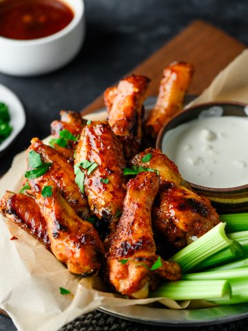 Tray with hot honey chicken wings, celery, and a blue cheese sauce