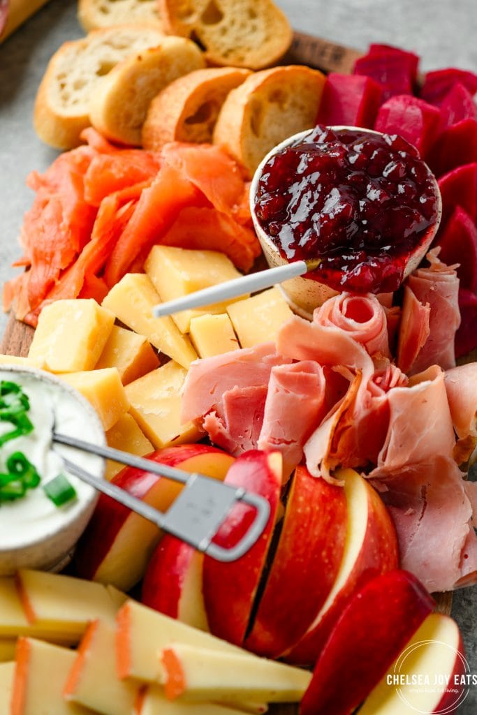 Closeup of smoked ham, lox, and cheese on a charcuterie board