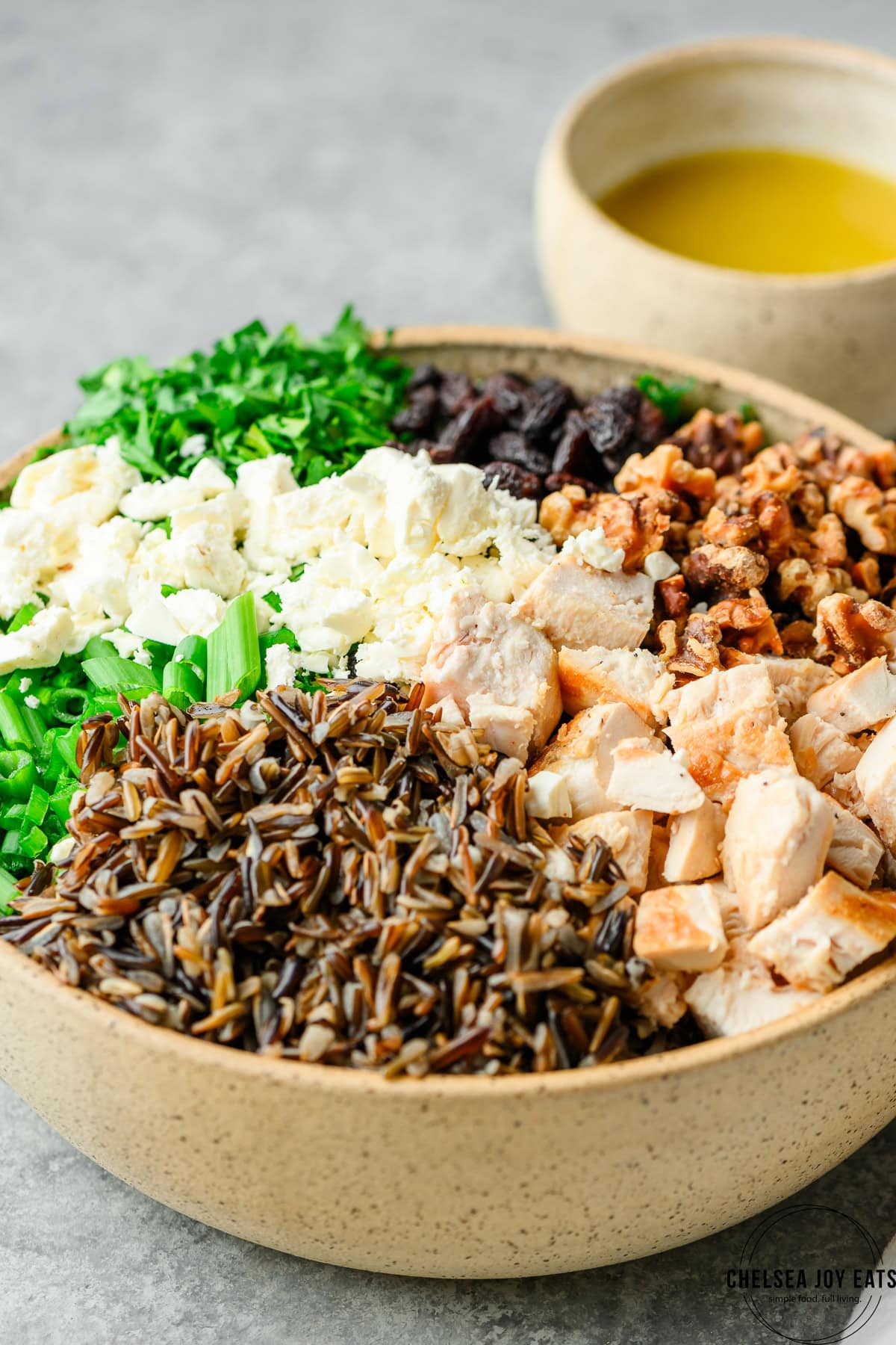 Closeup of chicken and kale wild rice salad ingredients arranged in a bowl