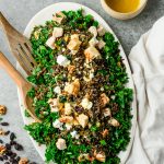Platter with wild rice, kale, and chicken salad garnished with feta and raisins