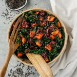 Serving bowl filled with tossed beet and butternut squash salad with wild rice