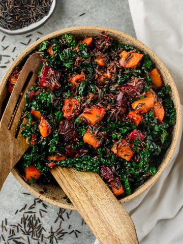 Serving bowl filled with tossed beet and butternut squash salad with wild rice