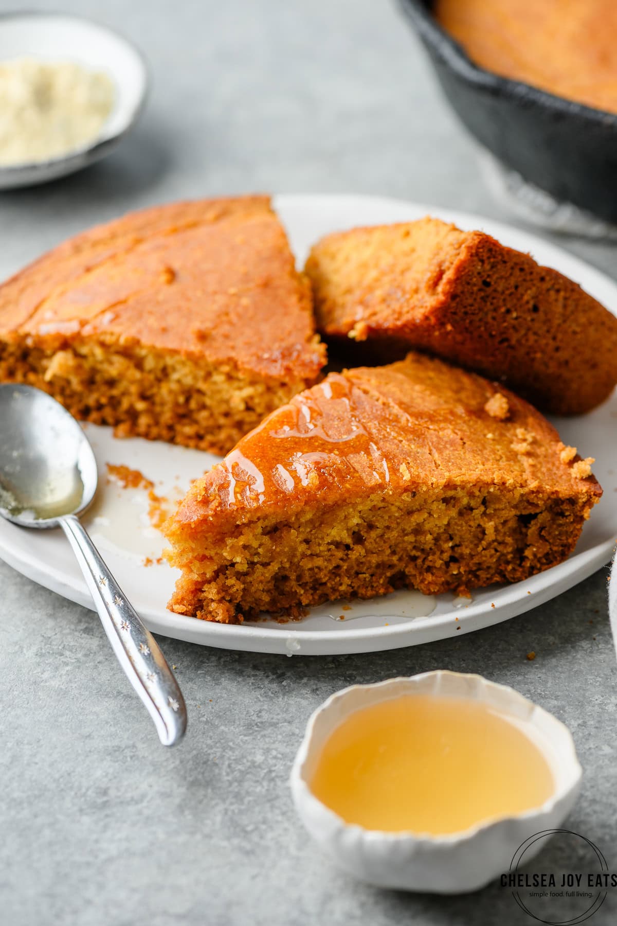 Slices of gltuen free cornbread on a plate and drizzled in honey