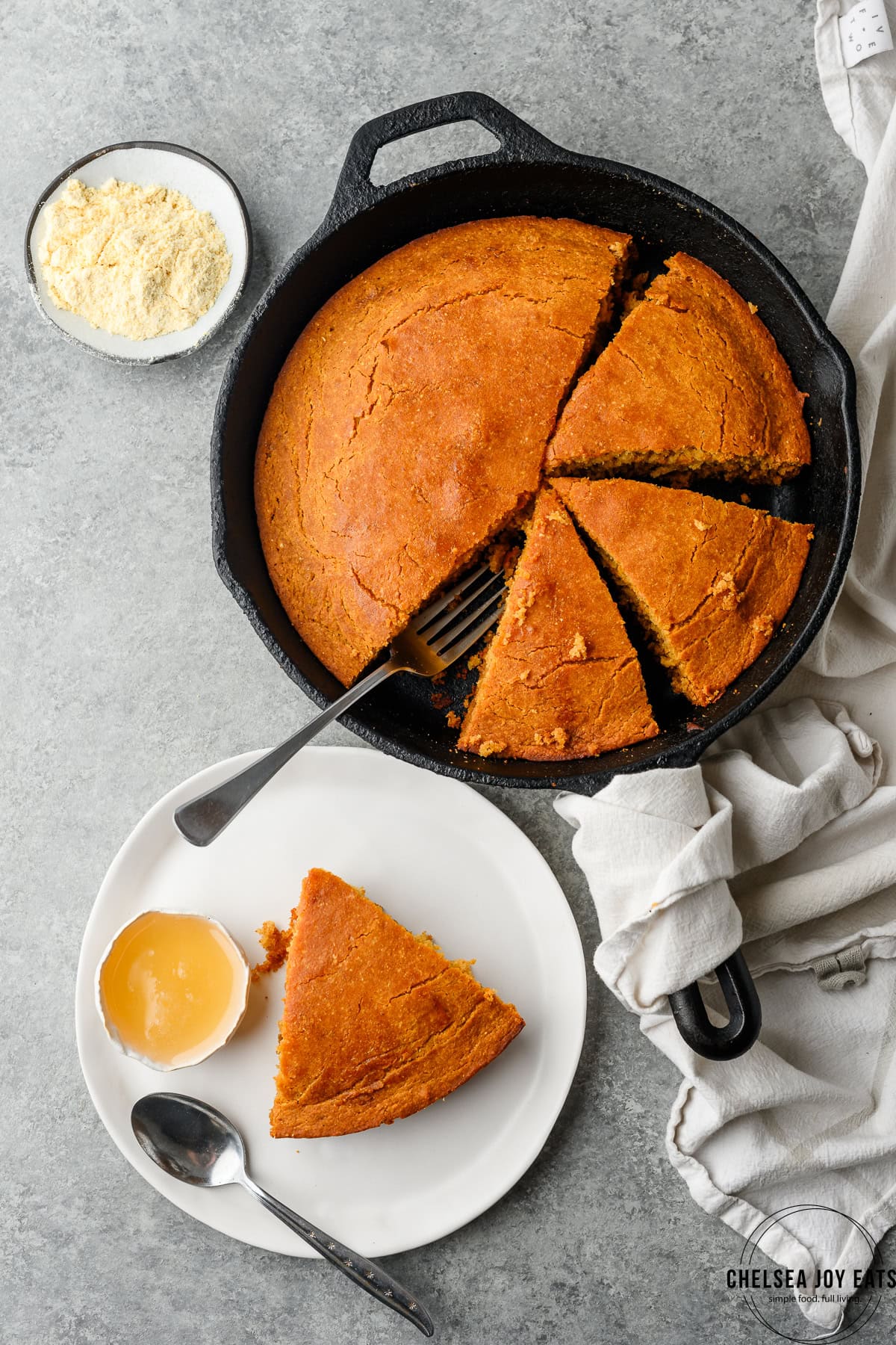 Bird's eye view of skillet gluten free cornbread cut up in a skillet with a slice served on a plate