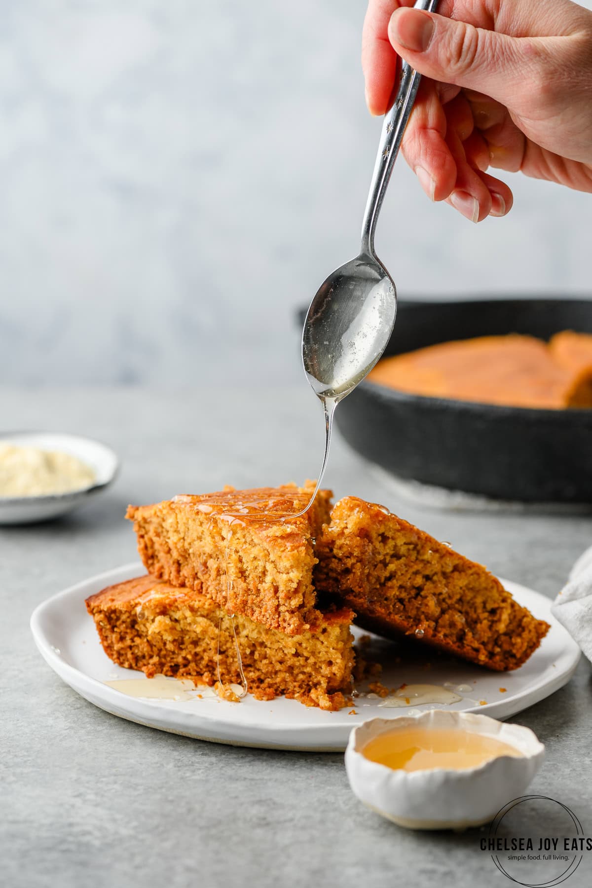 Slices of gluten free cornbread being drizzled with honey