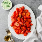 Serving platter with glazed honey-orange carrots with an herb dressing on the side