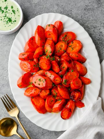 Serving platter with glazed honey-orange carrots with an herb dressing on the side