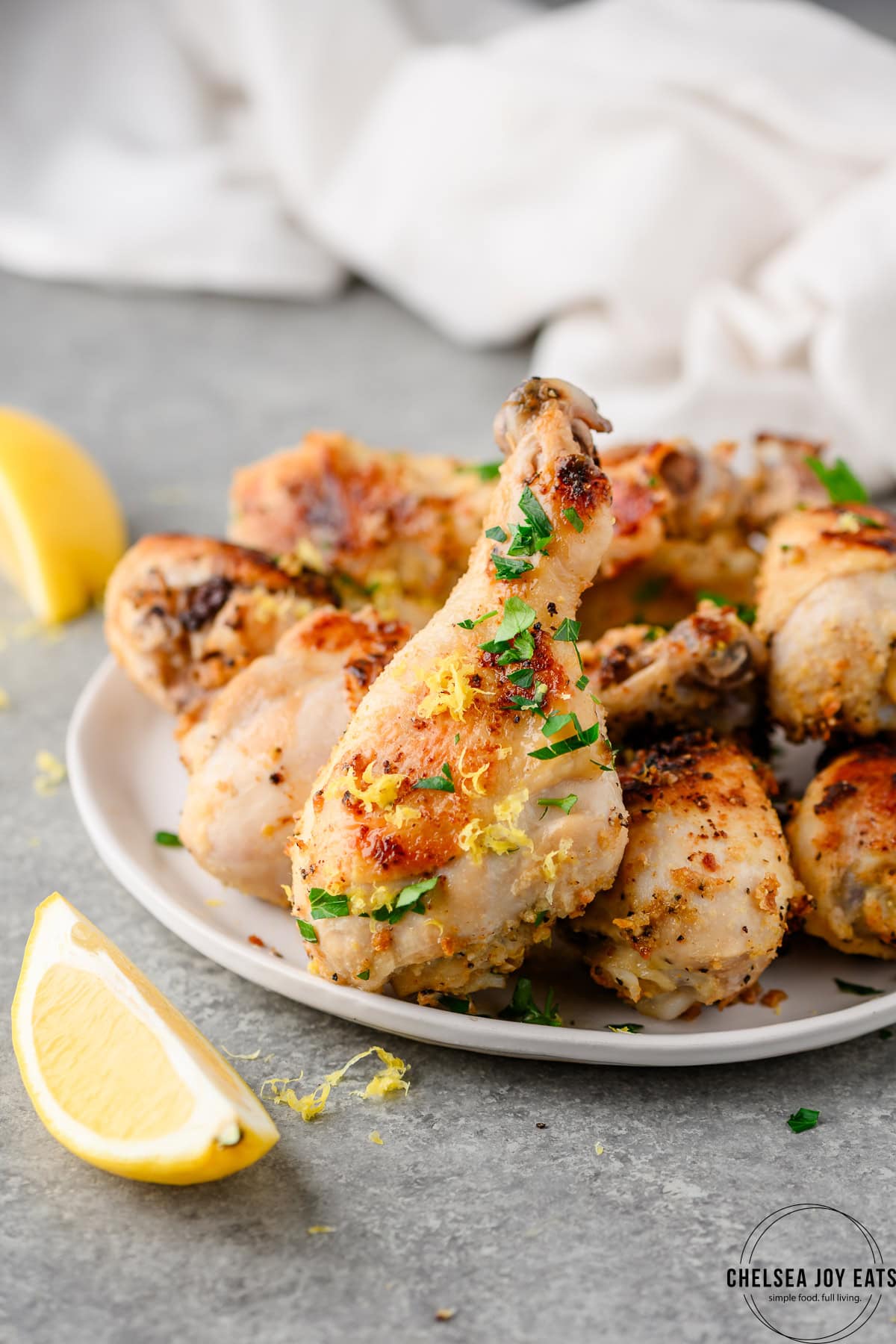 Closeup of lemon pepper chicken drumsticks piled on a plate