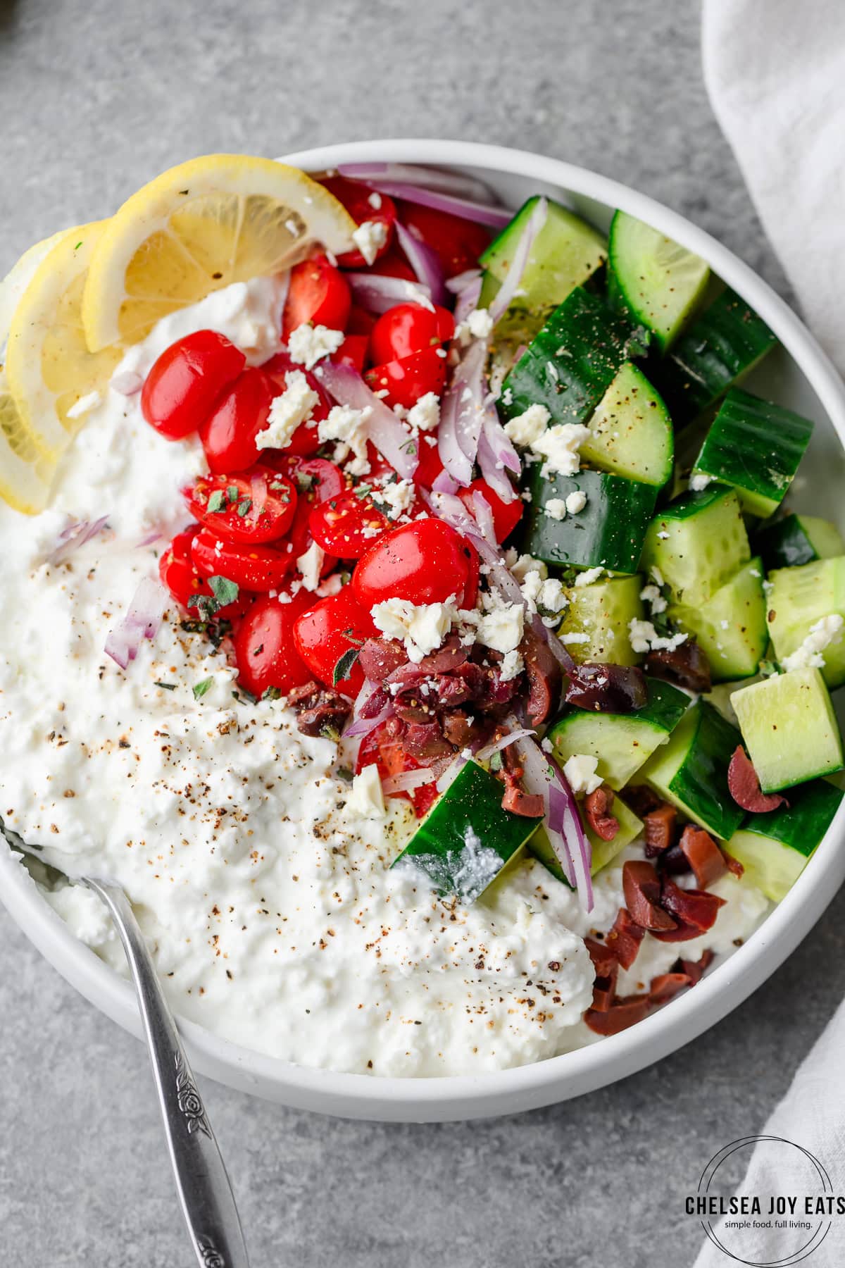Closeup of Greek cottage cheese bowl with cucumbers, tomatoes, olives, and feta cheese