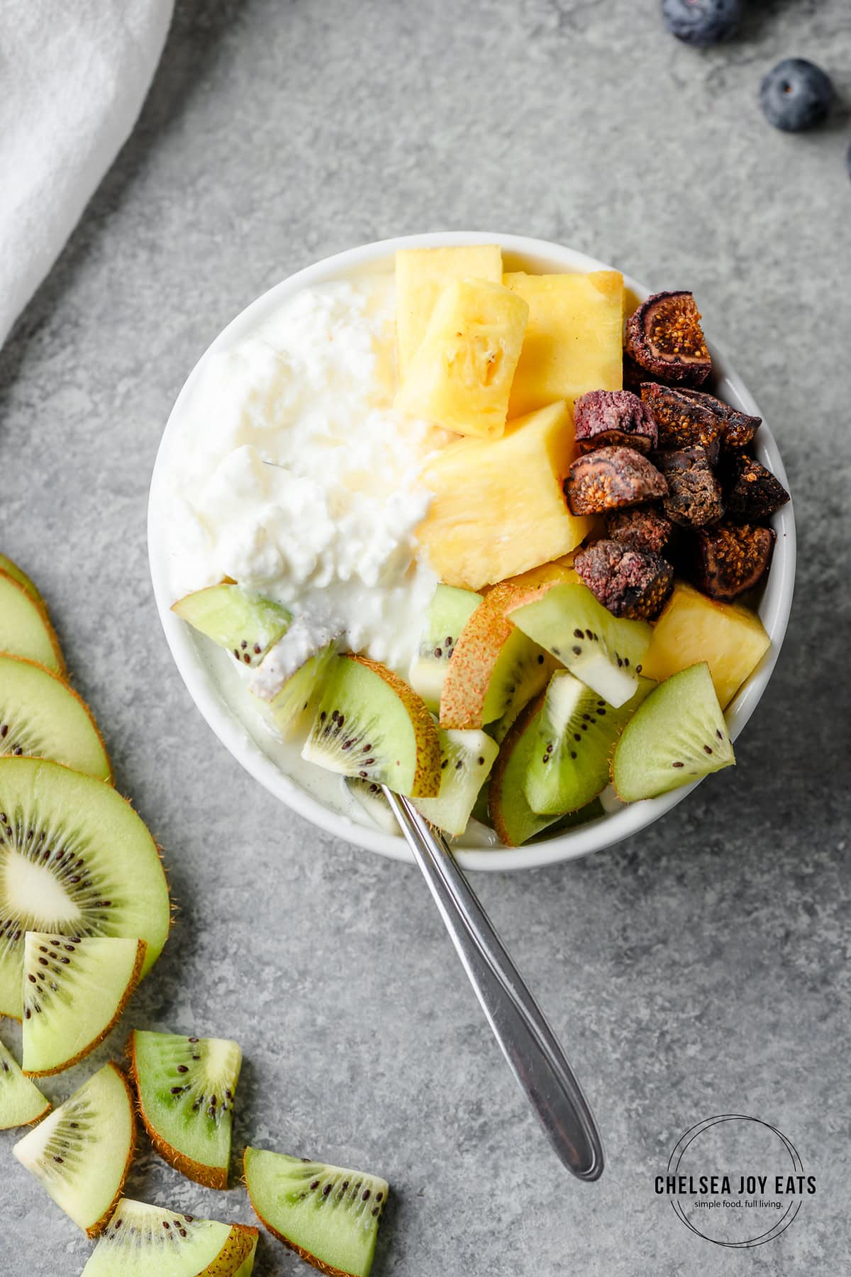 Bowl with cottage cheese, pineapple, kiwi, and dried figs